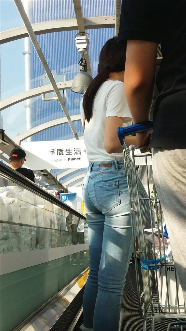 街拍紧身浅蓝牛仔裤圆屯戴眼镜的美眉[653M]