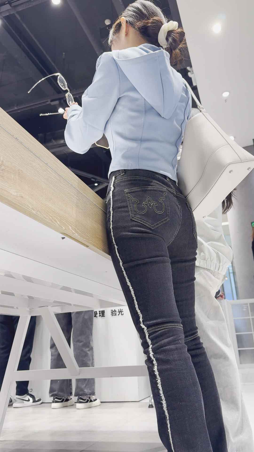 牛仔裤完美地贴合她性感的紧致臀部