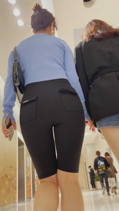 黑色紧身裤美女陪着闺蜜走扶梯